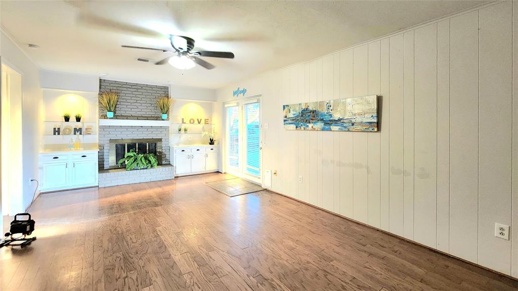 1911 Greenhaven Drive Richardson, TX 75080 - Photo 12 of 38 wooden floor in an empty room with a fireplace