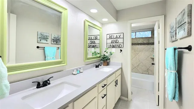 a bathroom with a tub sink and mirror