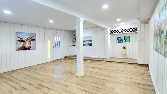 a view of a big room with wooden floor and windows