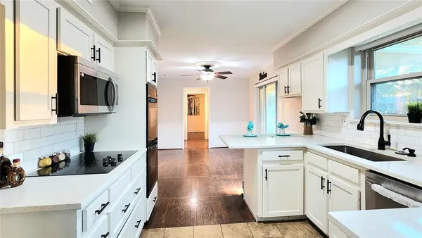 a kitchen with stainless steel appliances a sink a stove and cabinets