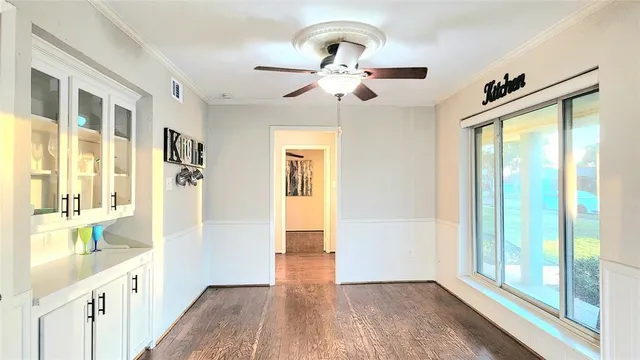 a view of a hallway with wooden floor and a living room