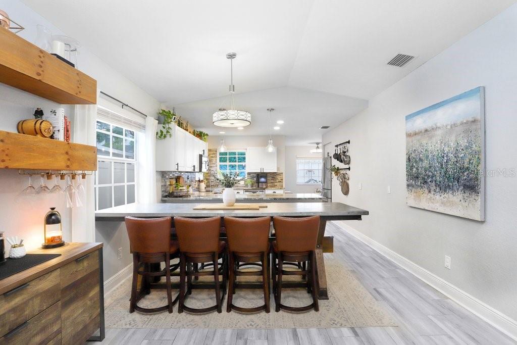 3122 West Grace Street Tampa, FL 33607 - Photo 12 of 46 a dining room with stainless steel appliances a table chairs and a kitchen view