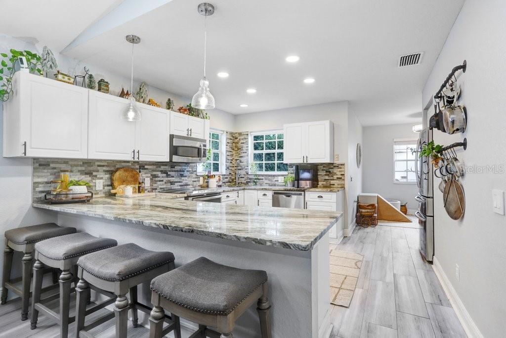 3122 West Grace Street Tampa, FL 33607 - Photo 14 of 46 a kitchen with stainless steel appliances granite countertop table chairs sink and cabinets
