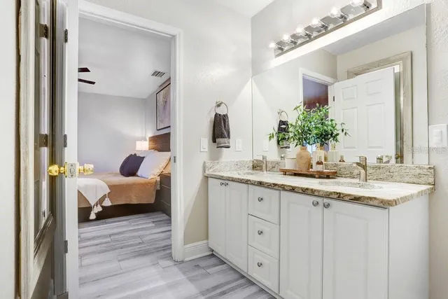 a spacious bathroom with a granite countertop sink and a mirror