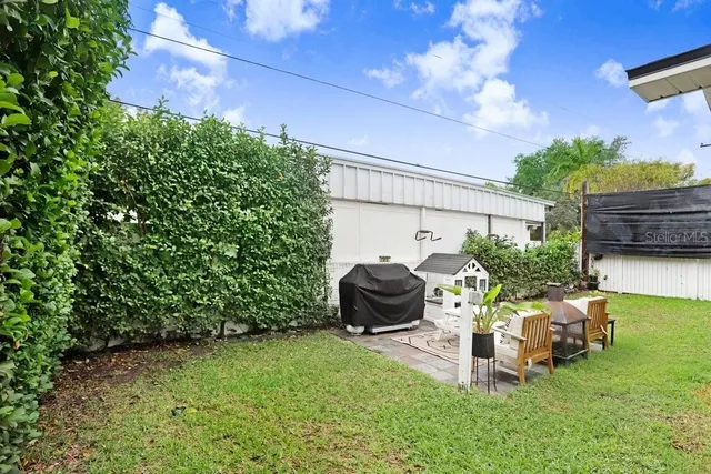 a view of a chair and table in backyard of the house
