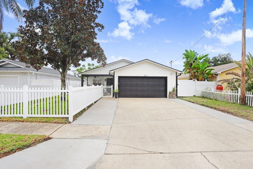 3122 West Grace Street Tampa, FL 33607 - Photo 30 of 31 a front view of a house with a garden and trees