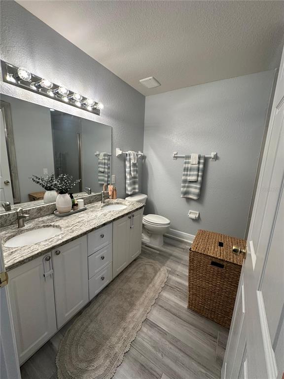 3122 West Grace Street Tampa, FL 33607 - Photo 30 of 46 a bathroom with a double vanity sink a mirror and a toilet