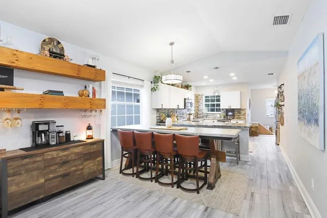 a kitchen with stainless steel appliances granite countertop a table chairs and a refrigerator