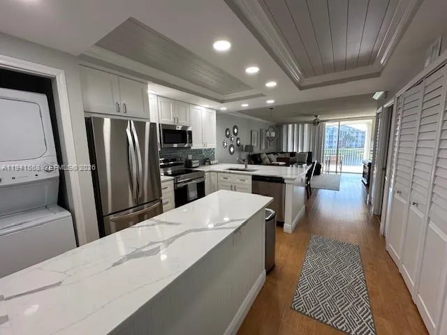 a kitchen with stainless steel appliances a refrigerator a sink a stove a microwave and wooden cabinets