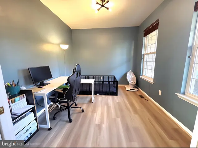 a view of a workspace with furniture and a window