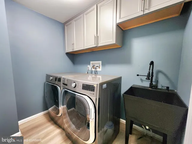 a utility room with sink dryer and washer