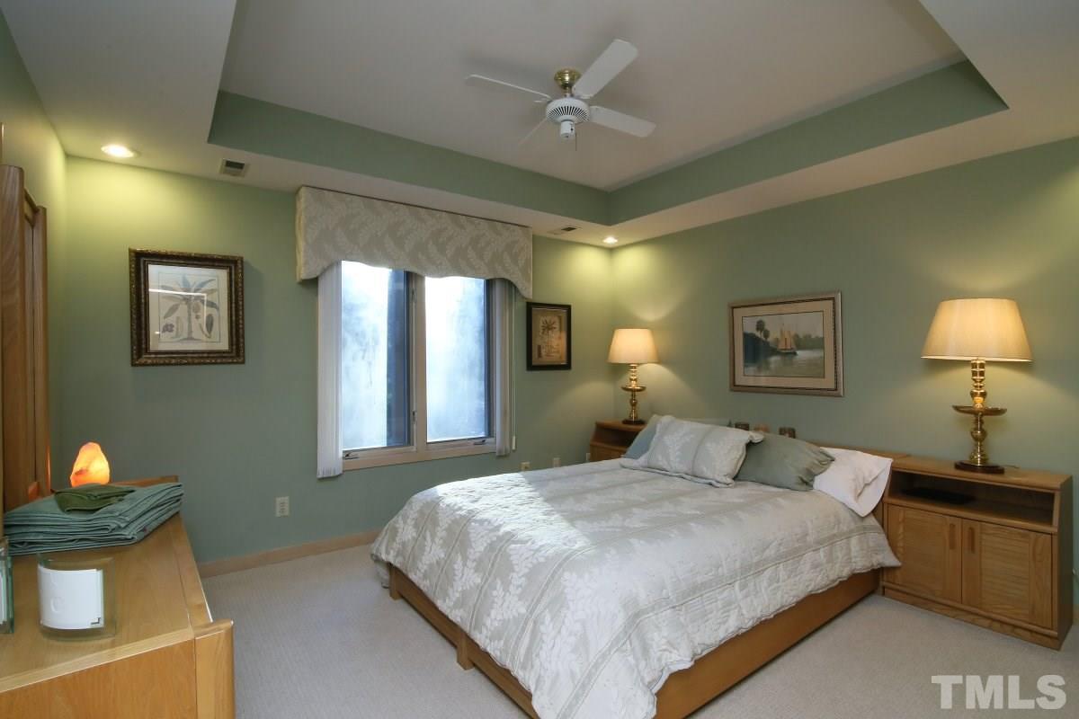 7209 Rainwater Road Raleigh, NC 27615 - Photo 20 of 25 a bedroom with a bed and a chandelier