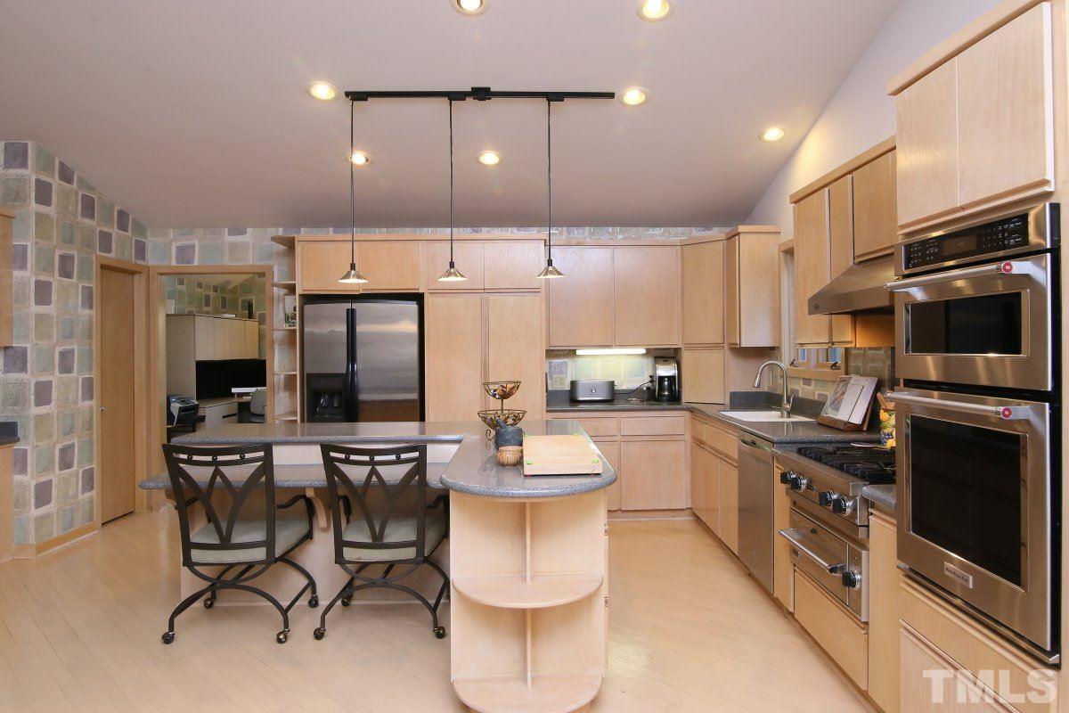 7209 Rainwater Road Raleigh, NC 27615 - Photo 9 of 25 a kitchen with stainless steel appliances wooden floor and a refrigerator