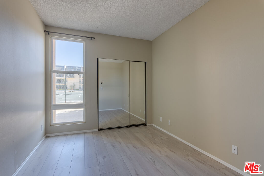 23901 Civic Center Way, Unit B137 Malibu, CA 90265 - Photo 11 of 27 an empty room with wooden floor and windows