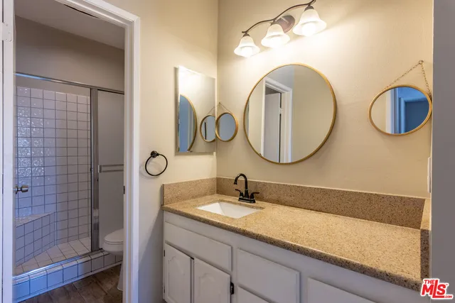 a bathroom with a granite countertop double vanity sink and a mirror