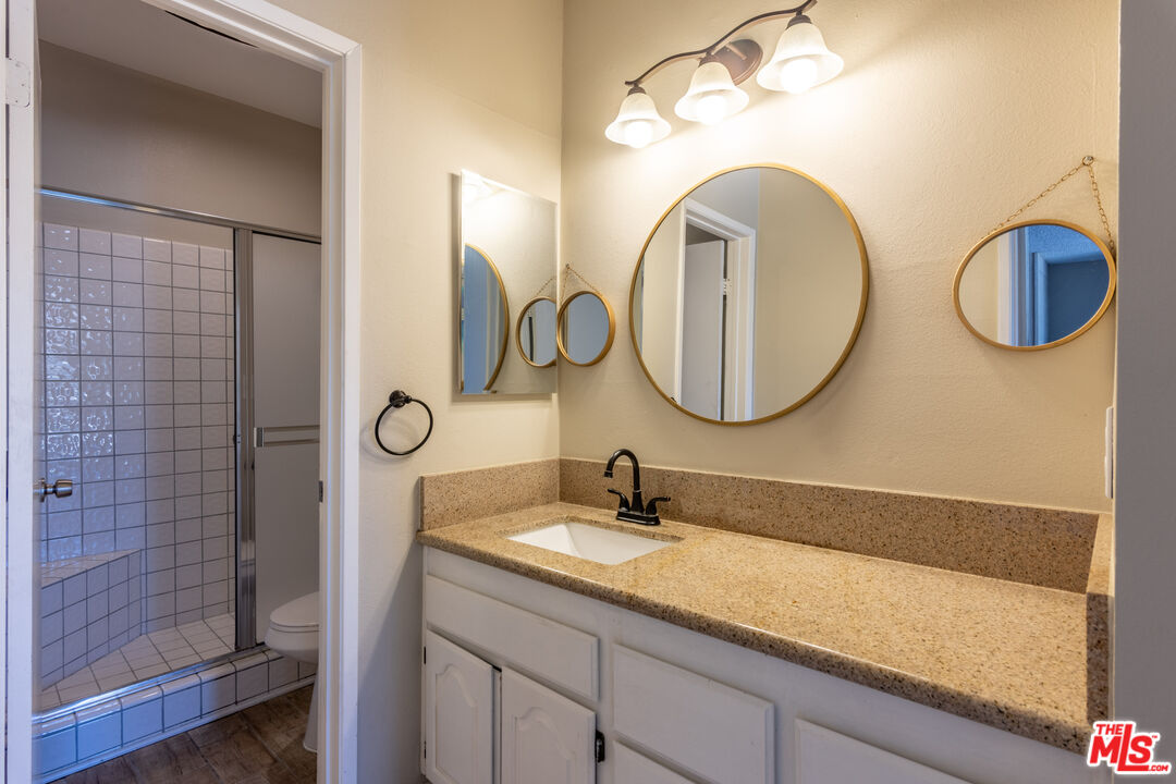 23901 Civic Center Way, Unit B137 Malibu, CA 90265 - Photo 12 of 27 a bathroom with a granite countertop double vanity sink and a mirror