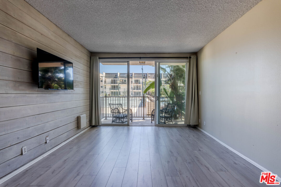 23901 Civic Center Way, Unit B137 Malibu, CA 90265 - Photo 4 of 27 a view of an empty room with wooden floor and a window
