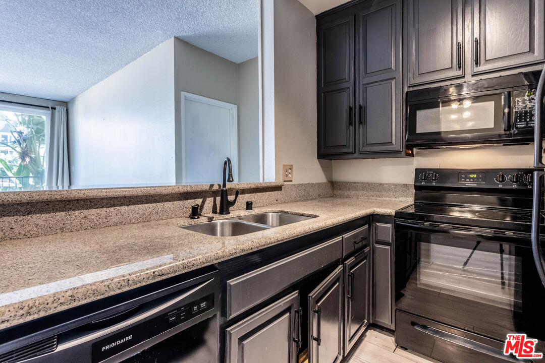 23901 Civic Center Way, Unit B137 Malibu, CA 90265 - Photo 7 of 27 a kitchen with a sink stove and cabinets