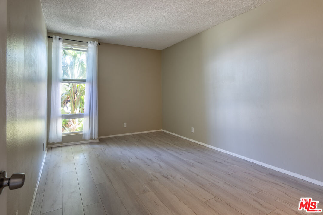 23901 Civic Center Way, Unit B137 Malibu, CA 90265 - Photo 8 of 27 an empty room with wooden floor and windows
