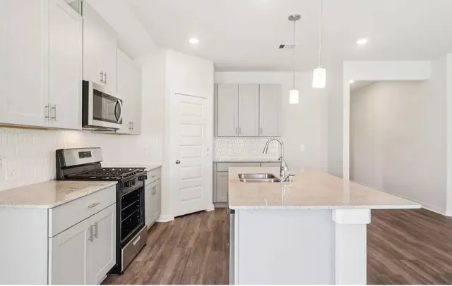 a kitchen with stainless steel appliances granite countertop a sink stove and refrigerator