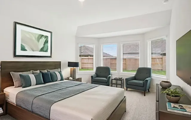 a bedroom with furniture and a flat screen tv