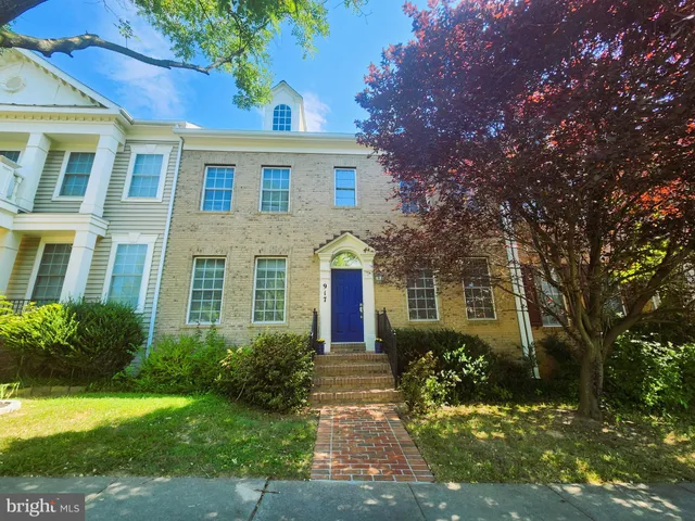 a front view of multi story residential apartment building with yard and green space