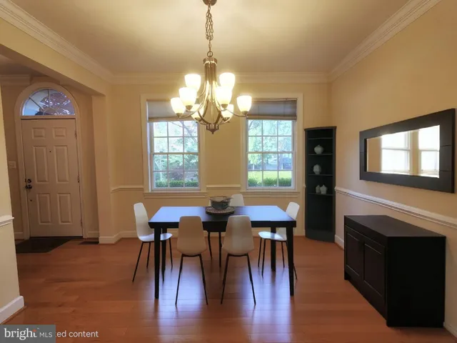 a view of a a dining room with furniture window and wooden floor