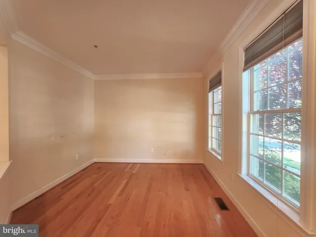 a view of a room with wooden floor and windows