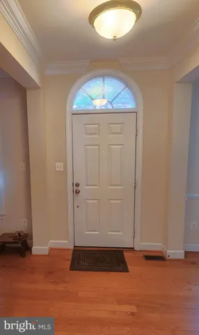 an empty room with wooden floor and cabinets