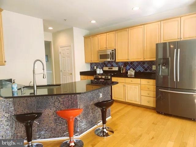 a kitchen with stainless steel appliances granite countertop a sink a stove and refrigerator