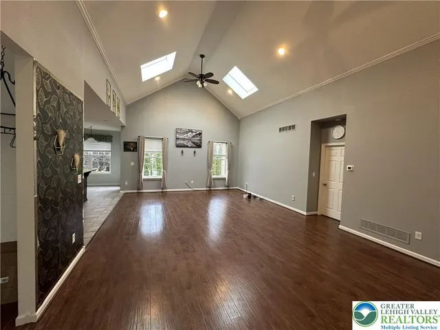 a view of an empty room with window and wooden floor