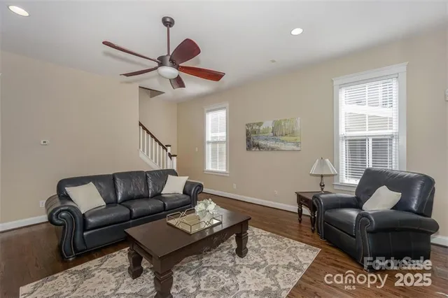 a living room with furniture wooden floor and a window