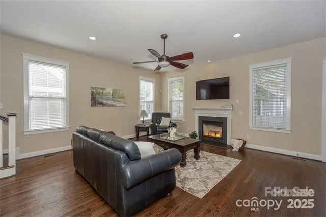 a living room with furniture a fireplace and a flat screen tv