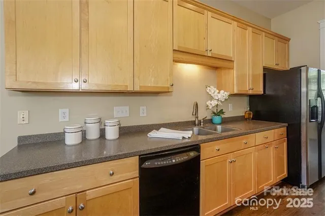 a kitchen with granite countertop a sink cabinets and stainless steel appliances