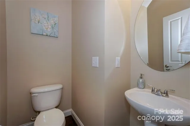 a bathroom with a toilet a sink and mirror
