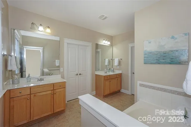 a spacious bathroom with a granite countertop sink a toilet a mirror and bathtub