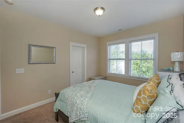 a bed sitting in a bedroom next to a window