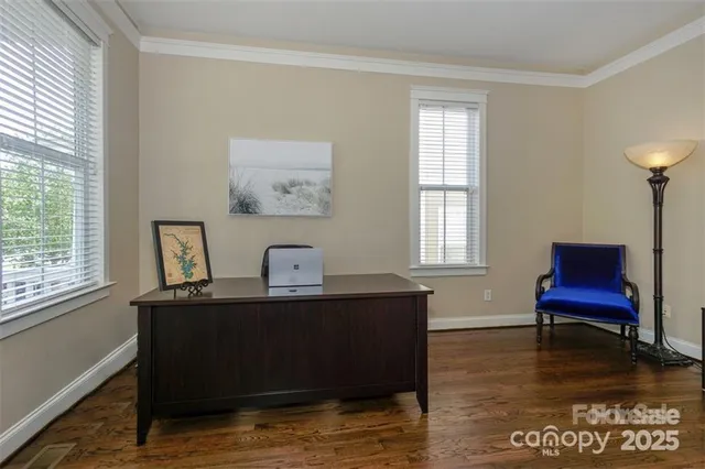 a view of a workspace with furniture and a window