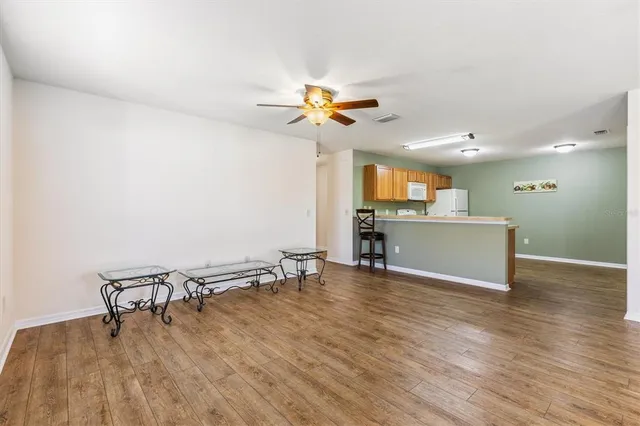a view of a room with a wooden floor and a ceiling fan