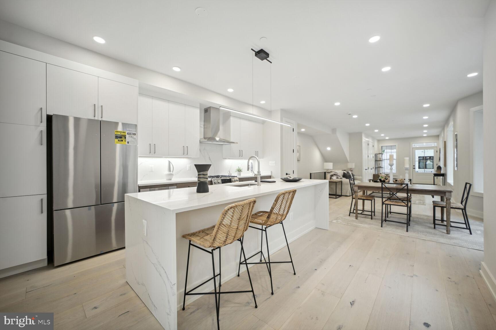 1744 Lanier Place Northwest, Unit 1 Washington, DC 20009 - Photo 11 of 39 a kitchen with stainless steel appliances a refrigerator a stove a sink a dining table and chairs