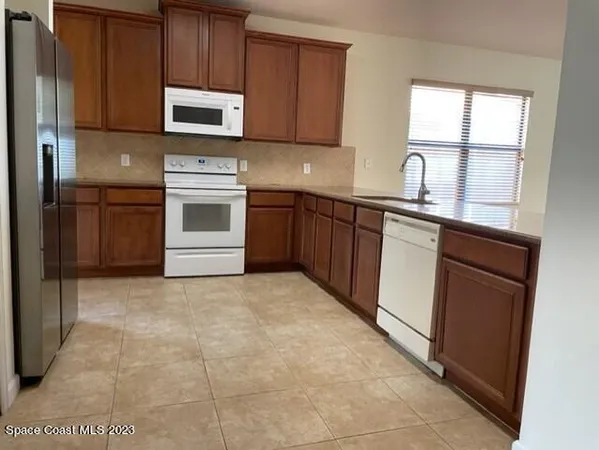 a kitchen with granite countertop a stove microwave and sink