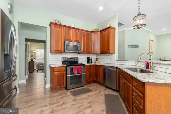a kitchen with stainless steel appliances granite countertop a sink refrigerator and cabinets