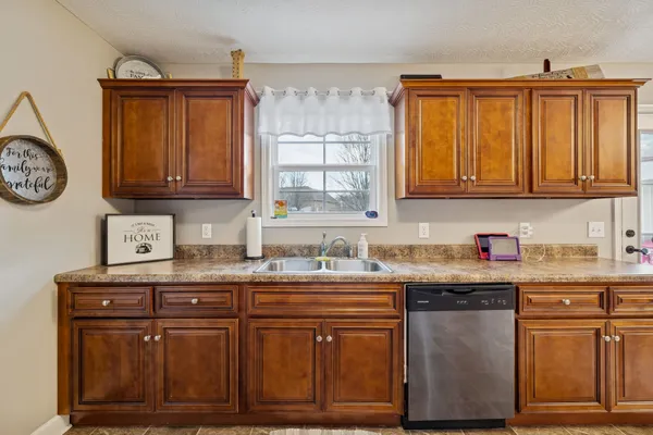 a kitchen with granite countertop a sink and cabinets