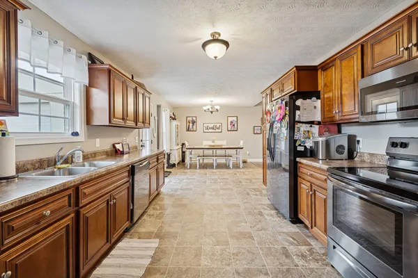 a large kitchen with stainless steel appliances granite countertop a stove and cabinets