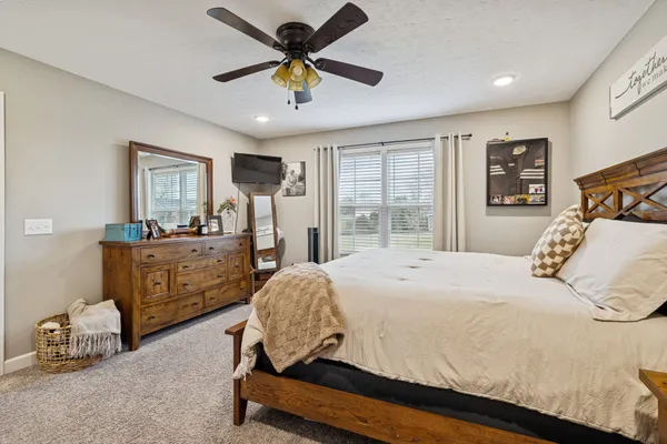 a bedroom with a bed a window and a chandelier
