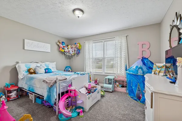 a bedroom with furniture a baby crib and a window