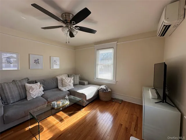 a living room with furniture and a flat screen tv with wooden floor