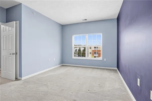 an empty room with closet and a bathroom