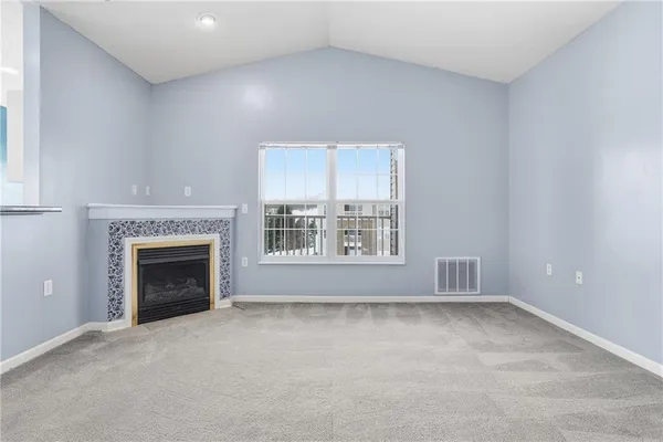 a view of a livingroom with a fireplace and window