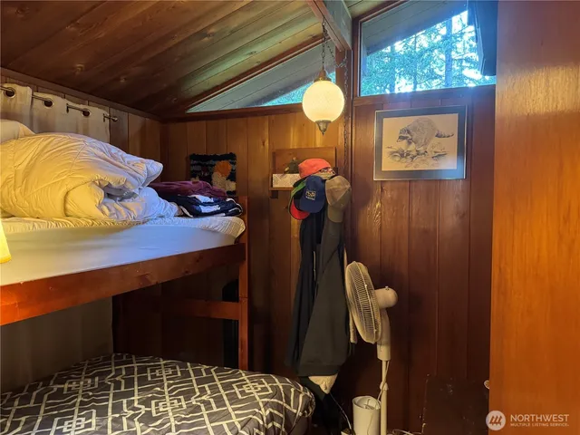 a bedroom with a bed and a lamp next to a window